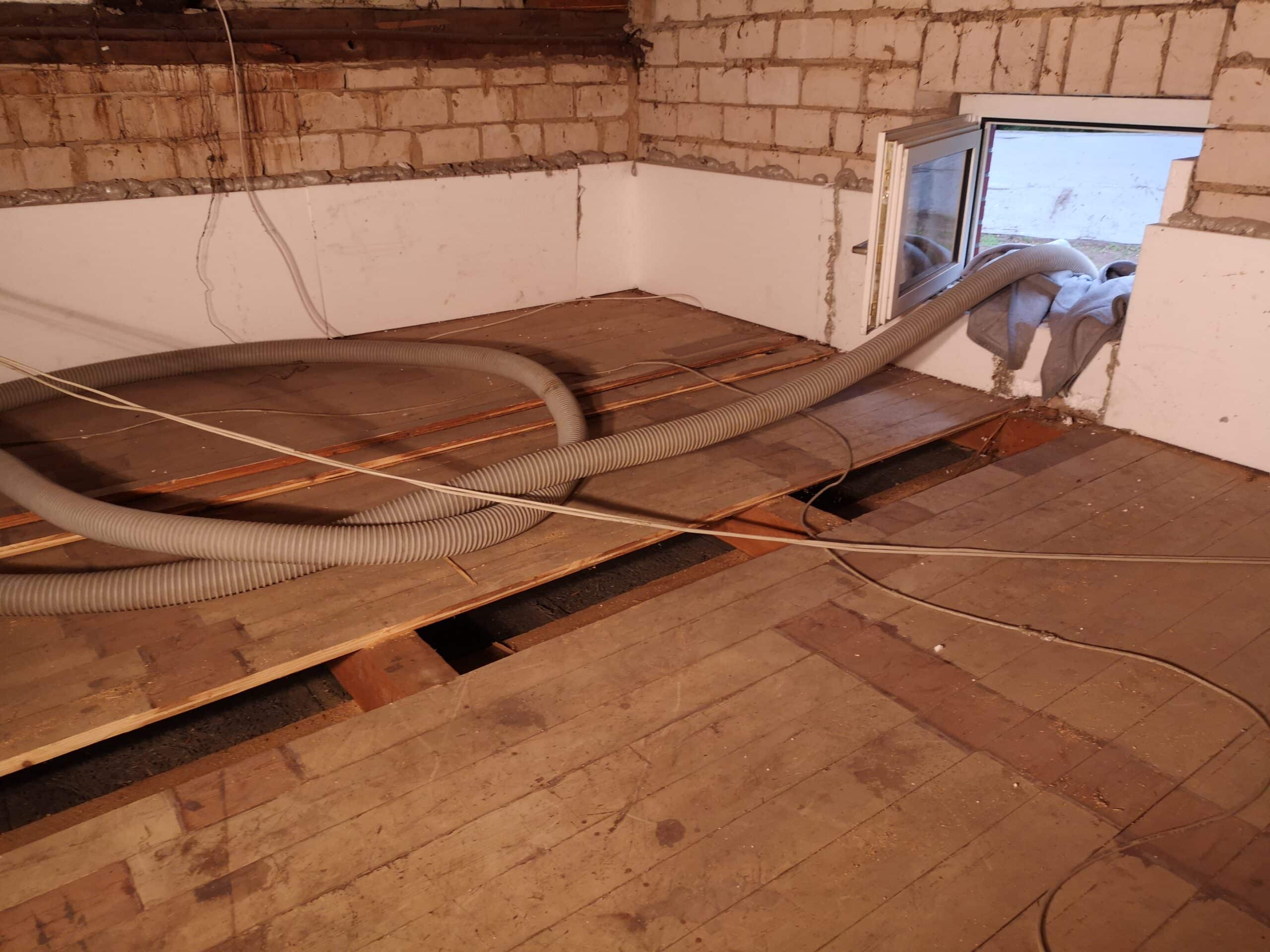 Einblasd&auml;mmung Dachboden &ndash; Einblasschlauch durch aufgenommene Dielen&ouml;ffnung in Holzbalkendecke