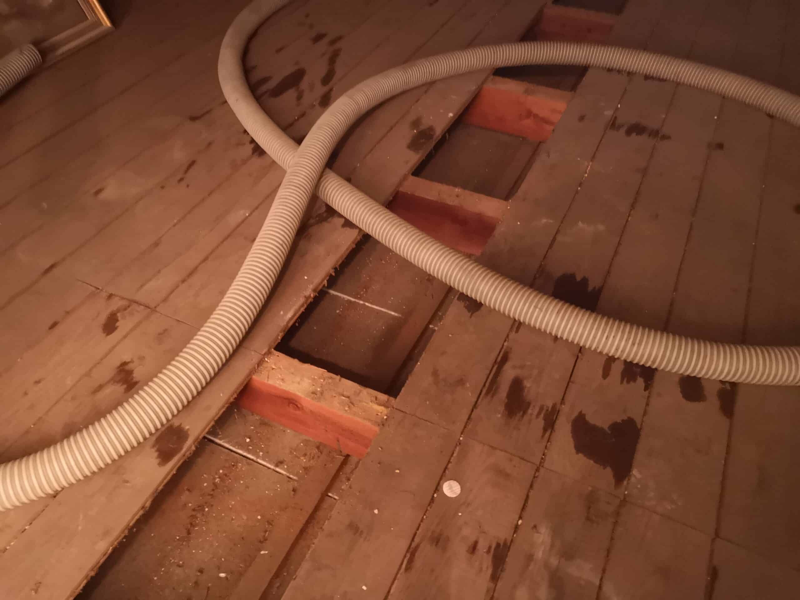 Detail Einblasd&auml;mmung Holzbalkendecke &ndash; Einblasschlauch in Dielen&ouml;ffnung f&uuml;r Dachbodend&auml;mmung